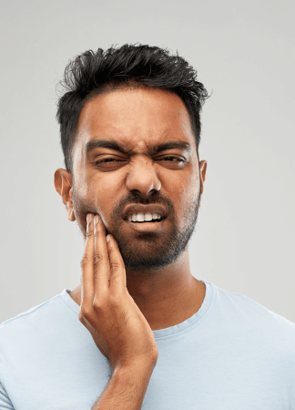 Man holding the side of his face portraying jaw numbness after wisdom teeth removal
