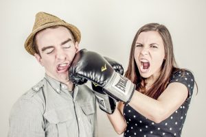 woman hitting man with a boxing glove