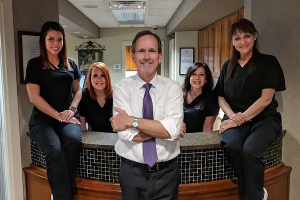 Dr. Duane Delaune with the Delaune Dental team at the office front desk