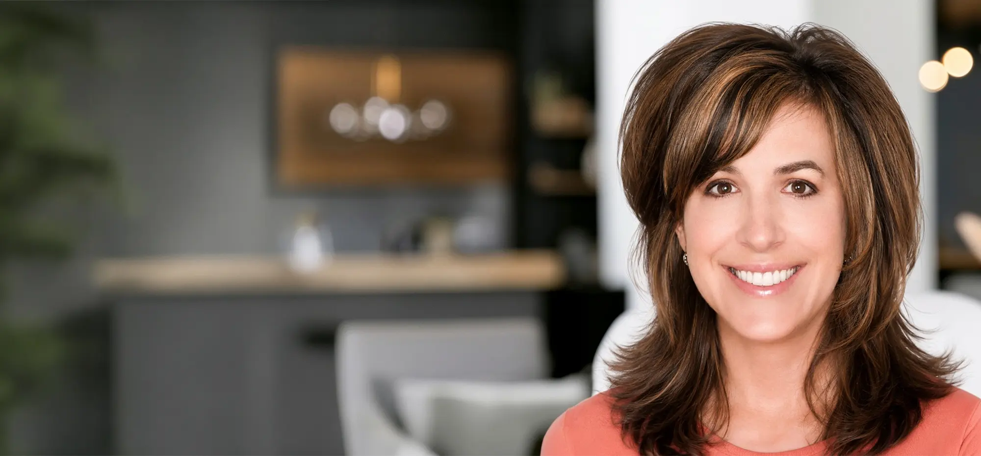 smiling woman with a beautiful open smile sitting in an elegant home setting